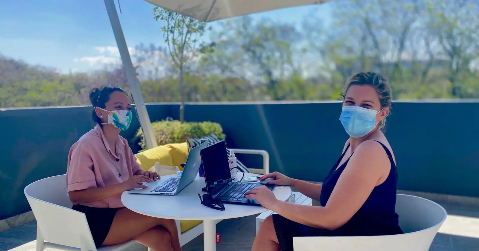 Guests working with laptops on the outdoor hotel terrace