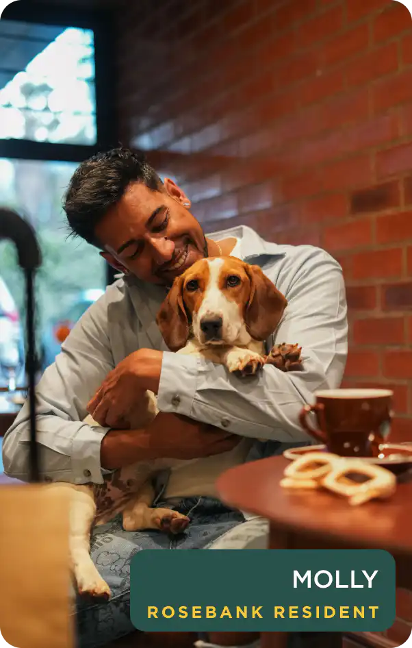 Guest cuddling Molly, a resident rescue dog at Home Suite Hotels Rosebank