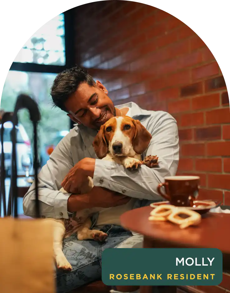 Guest cuddling Molly, a resident rescue dog at Home Suite Hotels Rosebank