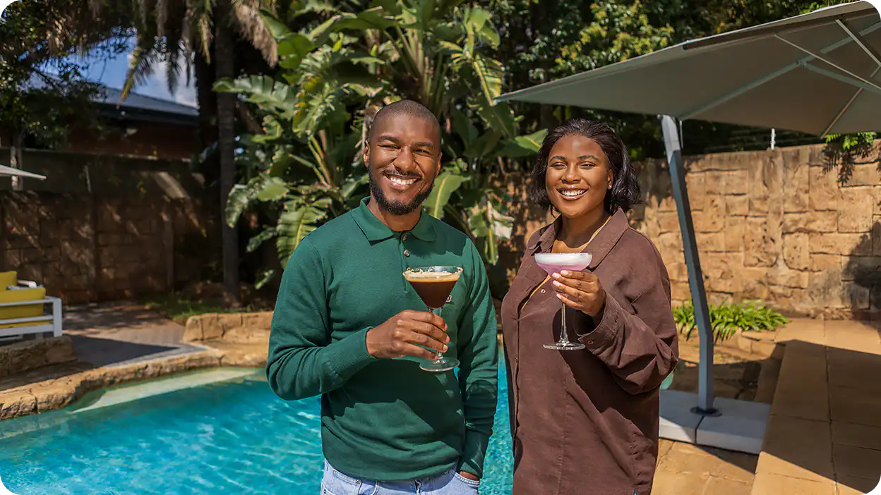 Guests enjoying cocktails beside the pool at Home Suite Hotels Rosebank