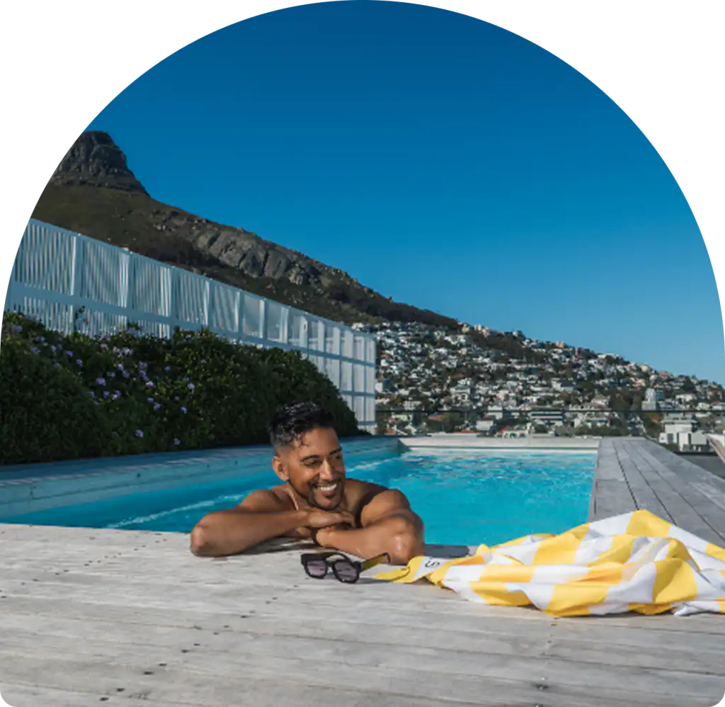 Guest relaxing in the rooftop pool at Station House in Sea Point, Cape Town, with Lion's Head views