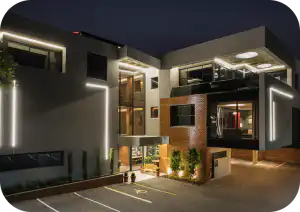Exterior of Home Suite Hotels Rosebank lit up at night, Johannesburg