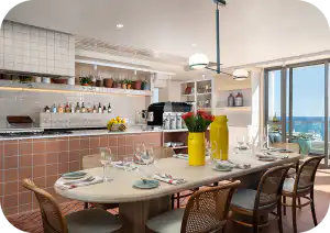 Communal kitchen and dining area at Home Suite Hotels Sea Point, with a set table and ocean views