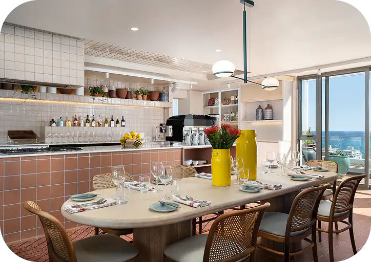Communal kitchen and dining area at Home Suite Hotels Sea Point, with a set table and ocean views